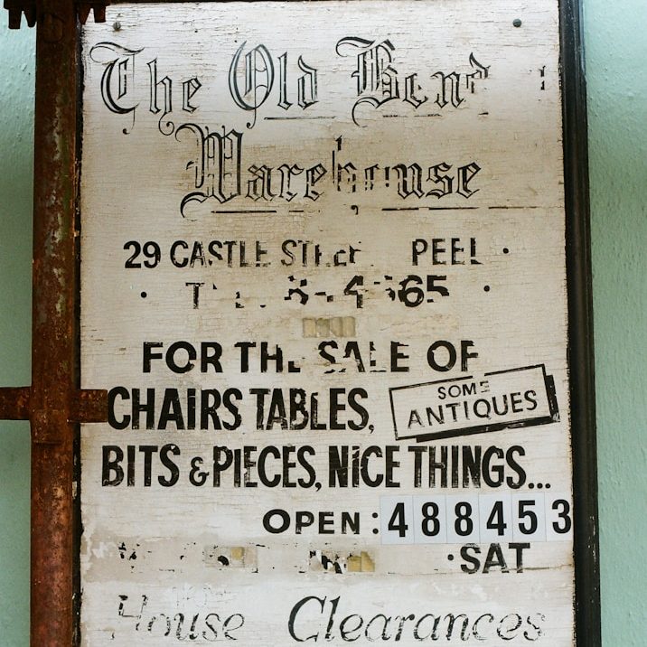 Altes Schild der Old Bend Warehouse mit Verkaufsangeboten für Möbel und Antiquitäten.